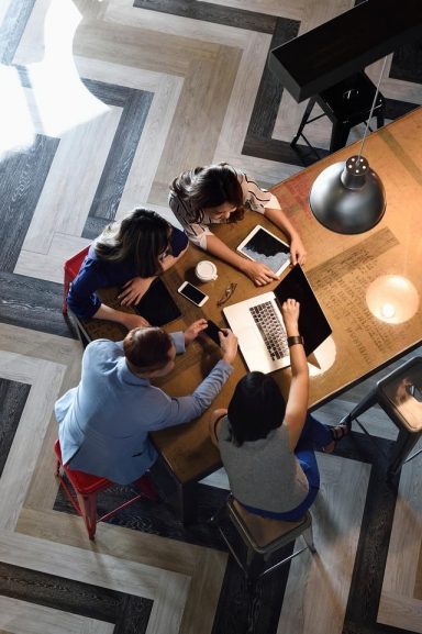 Jeunes collègues chinois travaillant ensemble dans un espace de coworking animé, vu d'en haut
