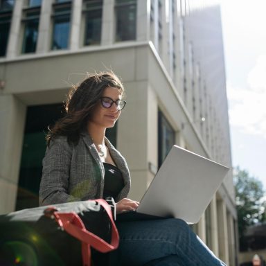 Young businesswoman working with laptop in a business area outdoors.