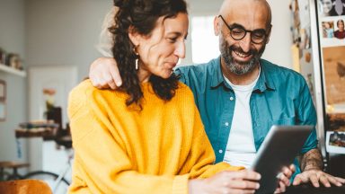Homme et femme souriant à l’iPad