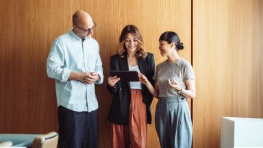 office workers grouped around tablet