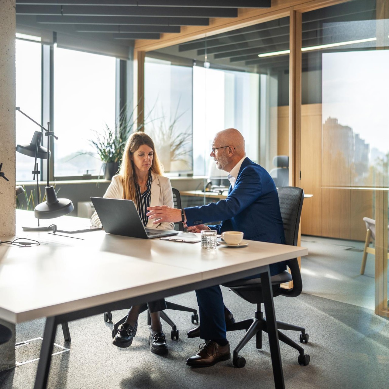 Man and woman having discussion in an open plan office