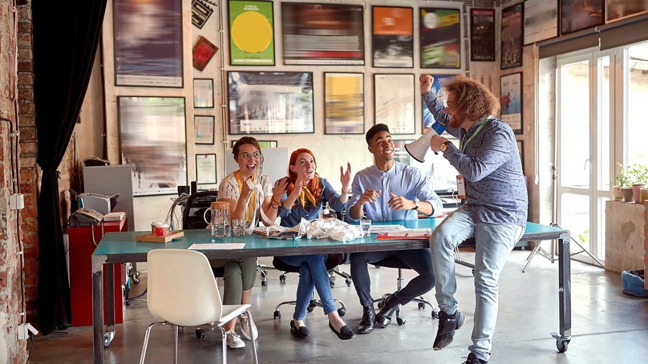 Group of young cheerful employees is having fun while working in the office together