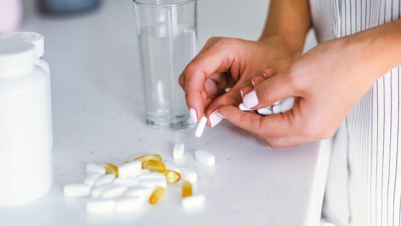 A young woman drinks pills