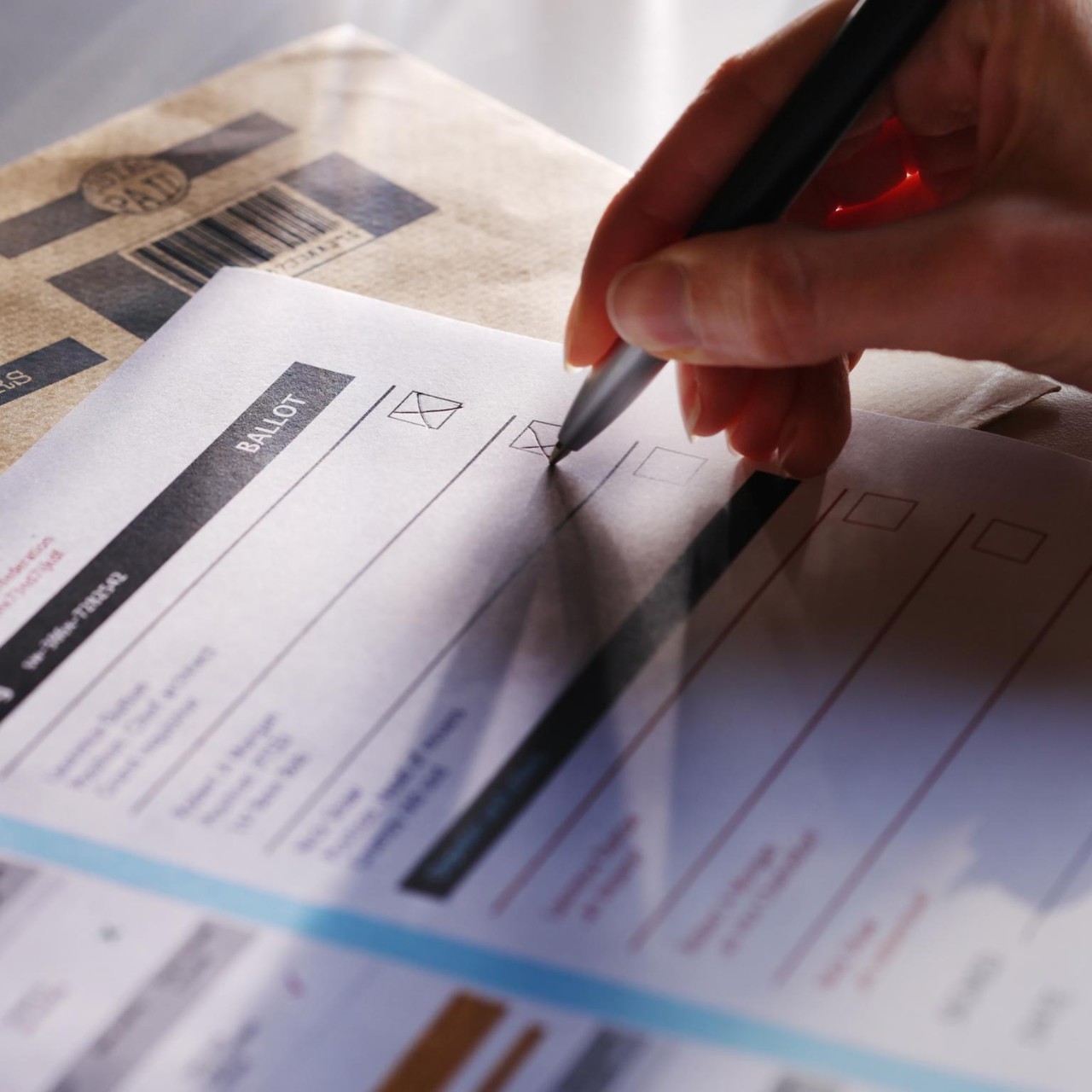 Stock image showing a woman’s hand filling in a postal ballot