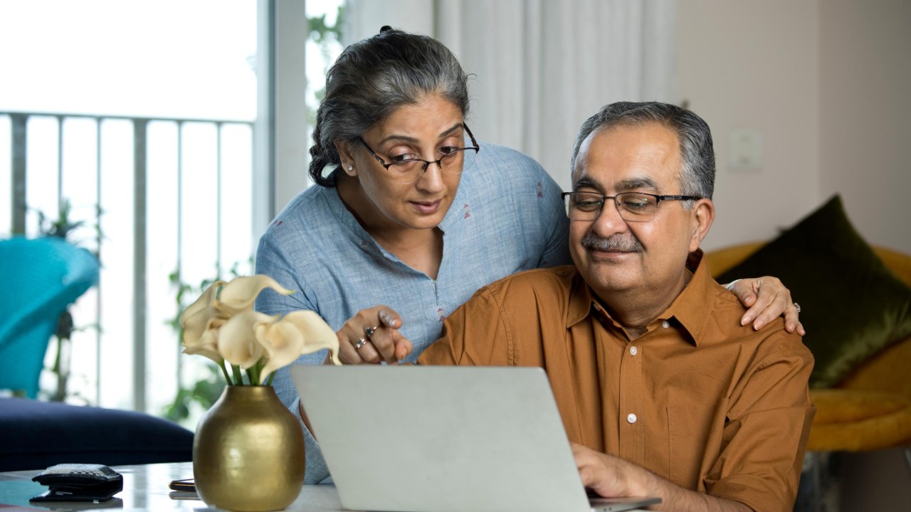 Senior couple using laptop while working on home budget