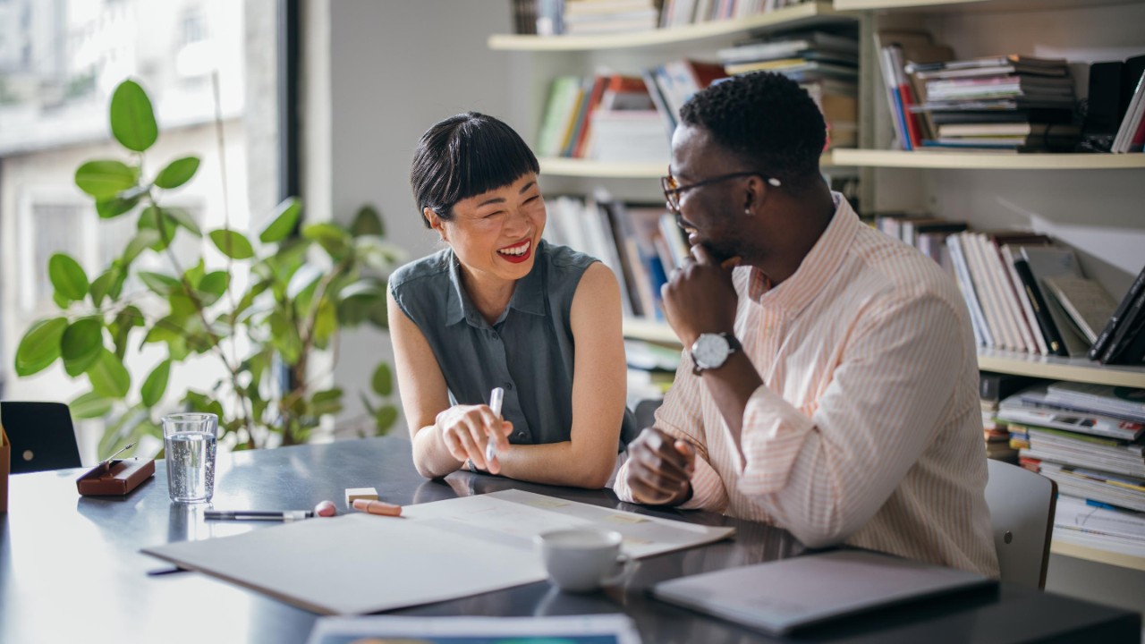smiling woman consulting male coworker