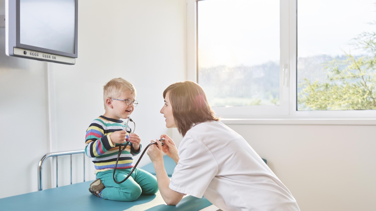 Female doctor and boy with stethoscope in medical practice, healthcare