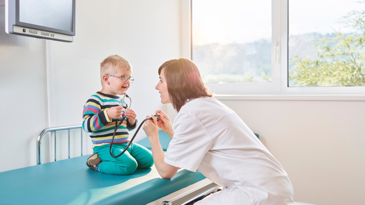 Female doctor and boy with stethoscope in medical practice, healthcare