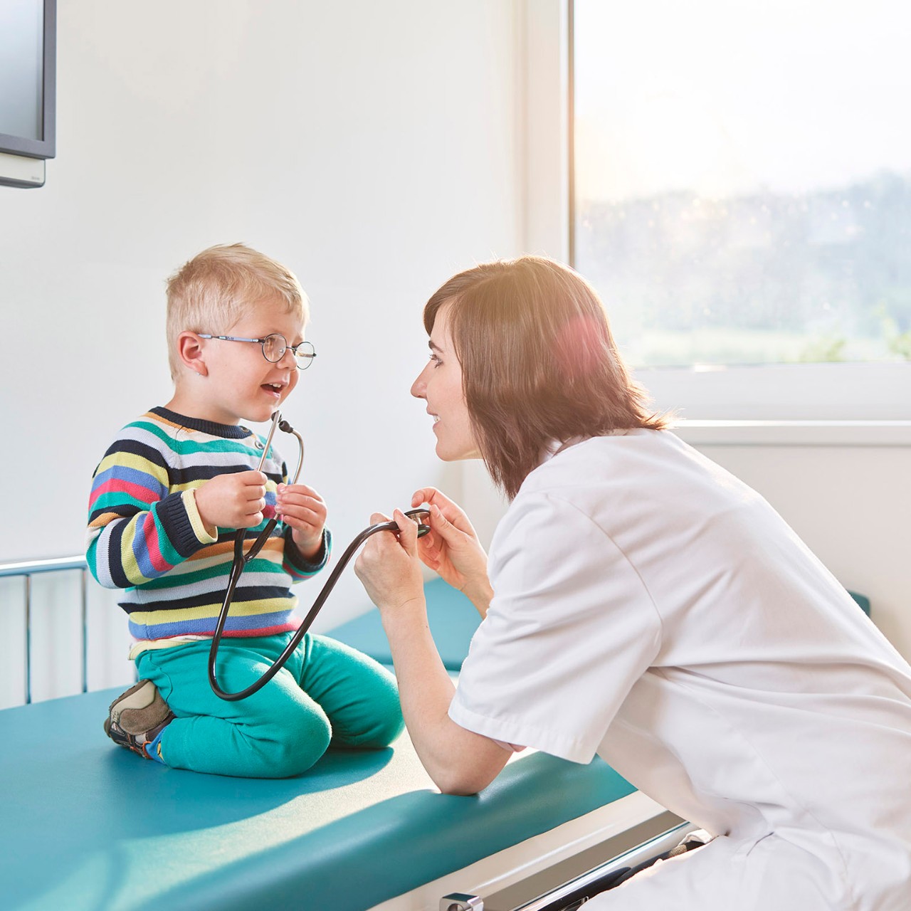 Female doctor and boy with stethoscope in medical practice, healthcare