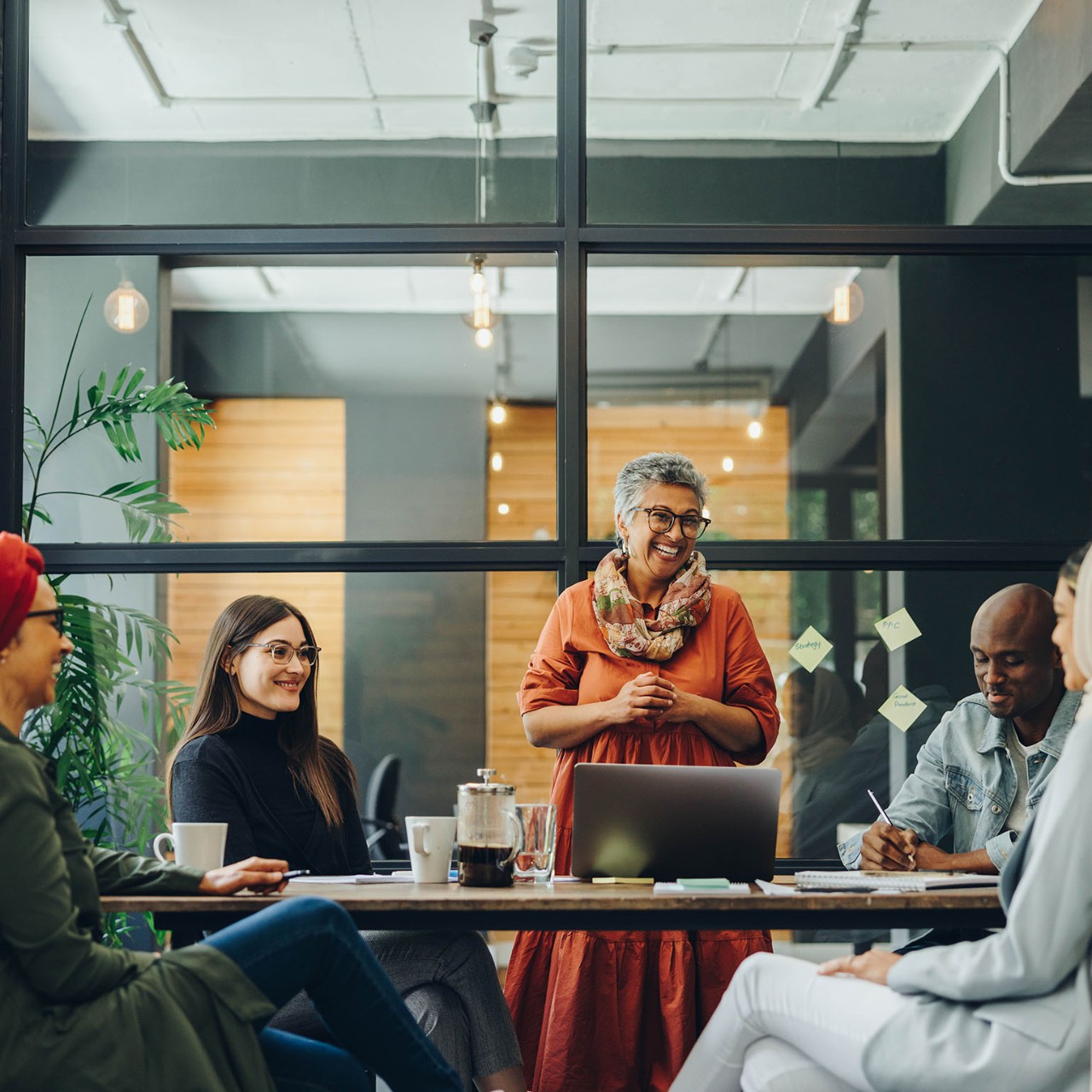 Successful businesspeople smiling happily during a meeting in a creative office. Group of cheerful business professionals working as a team in a multicultural workplace.