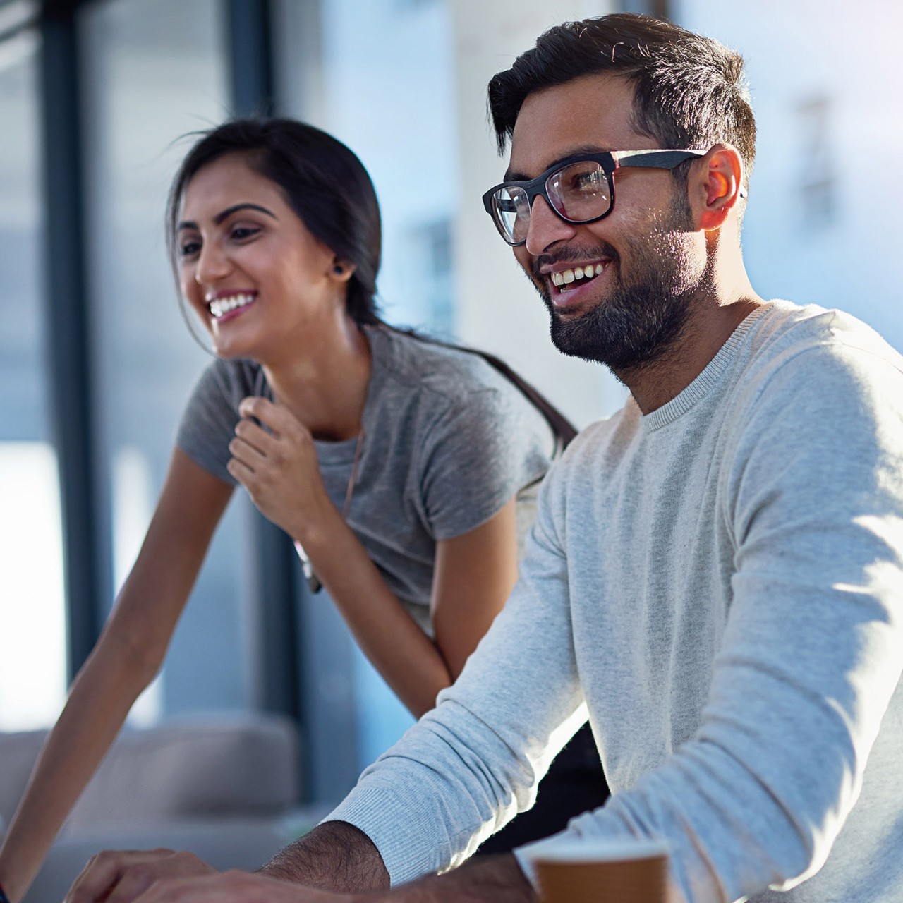 Shot of two young coworkers using a computer together at work