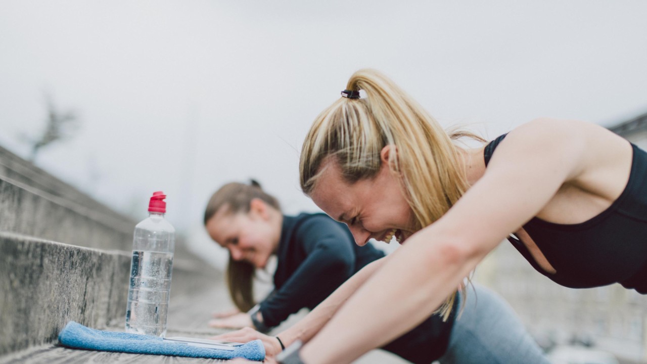 Girlfriends doing push-ups together and having fun